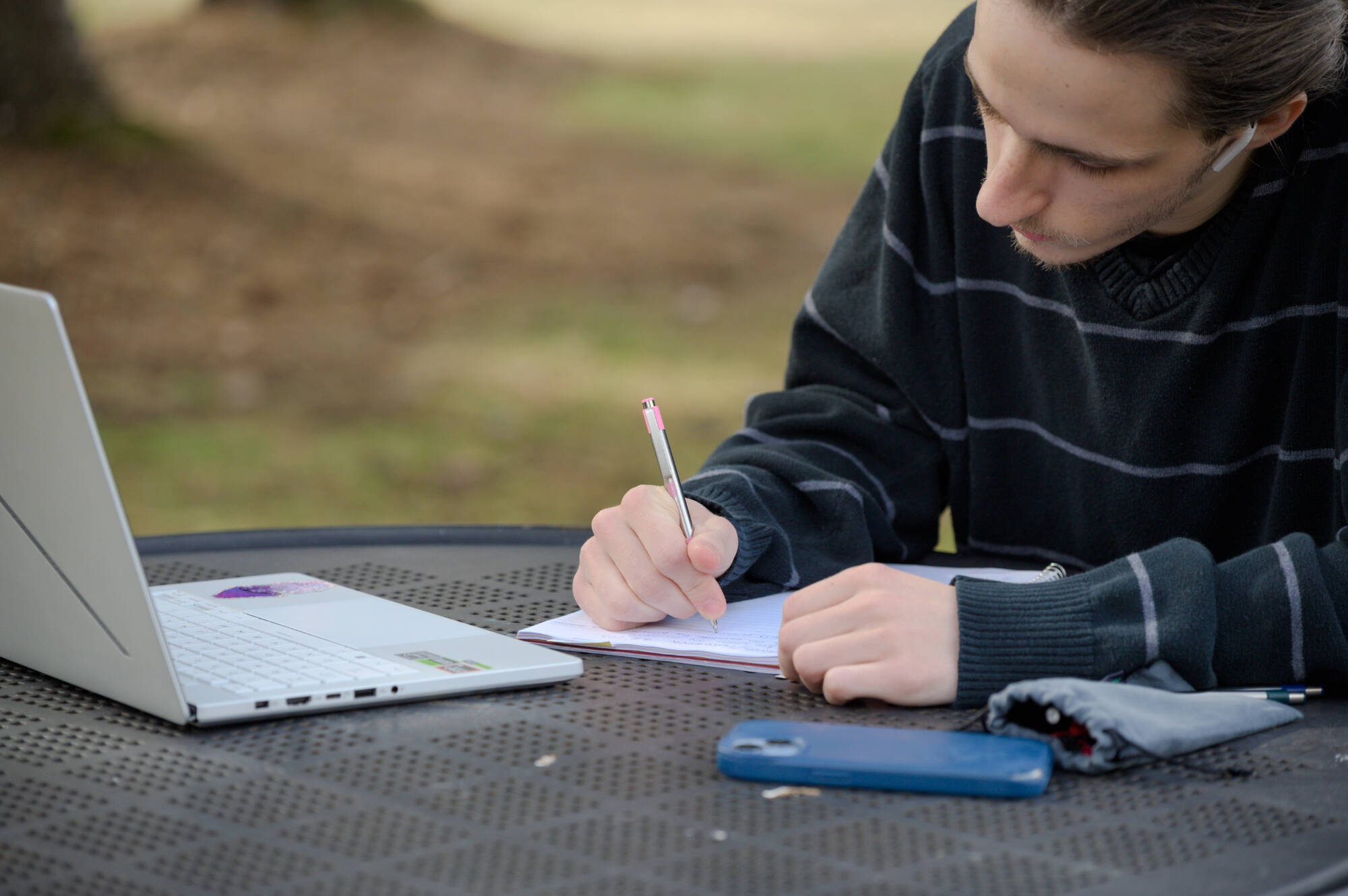 In the arboretum, mathematics and environmental and sustainability studies major Hunter Morningstar completes homework between classes.